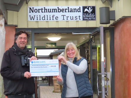 Mike Fielding from Birdersmarket handing over a cheque for £450 to Carolyn McMahon, Hauxley Wildlife Discovery Centre Reception and Information Assistant, image Sheila Luck.