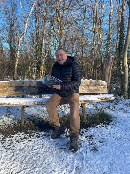 Image of NWT CEO, Mike Pratt, sitting on a bench on a snow-covered St Nicholas Park nature reserve.