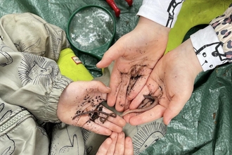 Four hands holding worms. Image by Rhiannon Studholme.