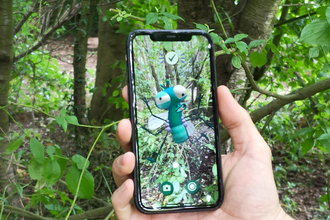 Lloyd of the Flies on a mobile phone in the woodland at Northumberlandia. Image by Lauren Brough.