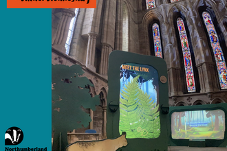 Display from the Missing Lynx exhibition. The image shows a life-size cut out of a lynx, a smalll tree, and a large interactive display screen.