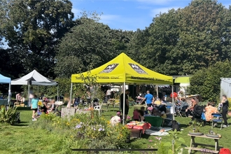Outdoor family event in a green space with 3 gazebos. 