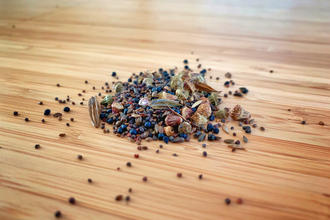 A pile of wildflower seeds on a wooden surface.