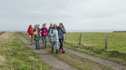 A group of women walking along a costal footpath