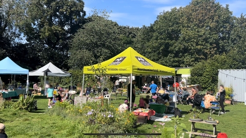 Outdoor family event in a green space with 3 gazebos.