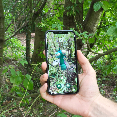 Lloyd of the Flies on a mobile phone in the woodland at Northumberlandia. Image by Lauren Brough.