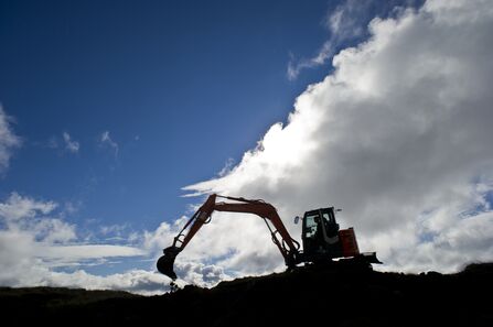 Bulldozer digging land at dusk. Image by Matthew Roberts.